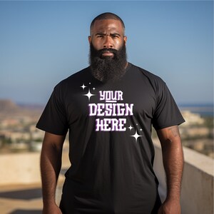 May include: A black t-shirt with the text "YOUR DESIGN HERE" in white with purple outlines and small white stars on either side of the text.
