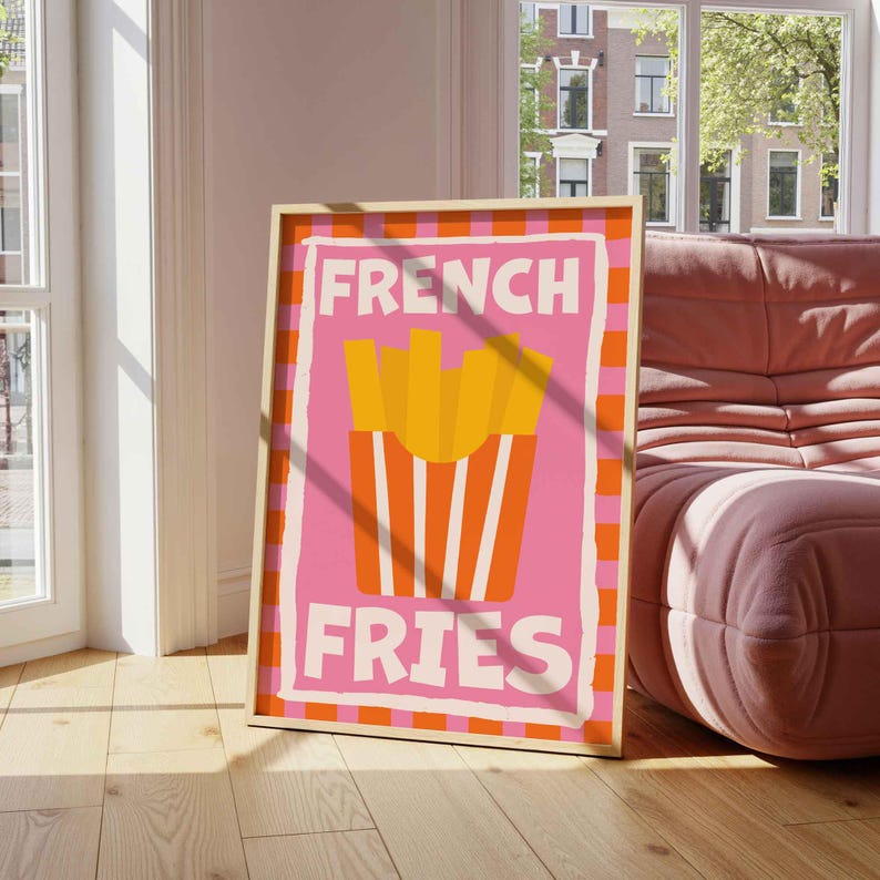 May include: A framed art print featuring a pink background with the words "FRENCH FRIES" in white. The image includes a graphic of yellow french fries in a red and white striped container, set against a pink and orange checkered border.