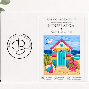 Puede incluir: Una caja rectangular blanca para un kit de mosaico de tela titulado Kinusaiga Beach Hut Retreat. La caja presenta el logotipo de Box Clever Crafts y una colorida ilustración de una caseta de playa, una gaviota, una pelota y flores.