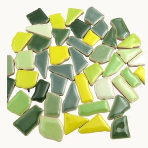 May include: A selection of mosaic tiles in various shades of green, yellow, and grey. The tiles are of different sizes and shapes, with a glossy finish. Suitable for craft projects or home decoration.