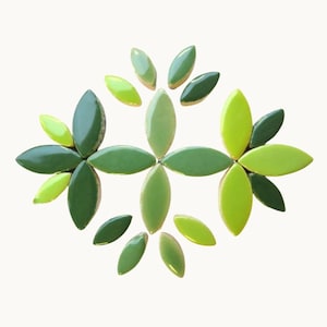 Puede incluir: Arreglo decorativo de baldosas verdes en forma de hojas, en tonos que van desde el verde lima claro hasta el verde bosque oscuro. Las baldosas están dispuestas en un patrón floral simétrico.