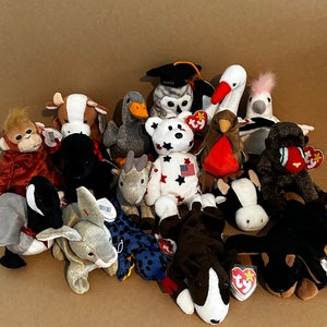 May include: A collection of 15 colorful beanie baby plush toys, including a black and white owl, a red cardinal, a gray duck, a brown and white cow, a white goose, a brown and white dog, a black and white cat, a white rabbit, a brown monkey, a black and white panda, a brown and white bear, a white and red reindeer, a brown and white horse, a brown and white pig, and a brown and white donkey.