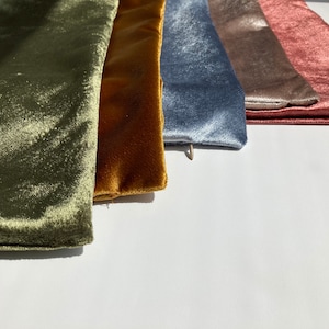 May include: Five velvet fabric swatches in different colors: olive green, mustard yellow, light blue, taupe, and dusty rose.