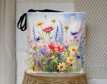 May include: A white tote bag with a watercolor painting of a field of colorful wildflowers. The flowers are in shades of pink, red, yellow, blue, and purple.