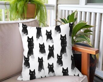 May include: White throw pillow with a black and white pattern of cats. The cats are facing forward and have black eyes. The pillow is made of a soft, comfortable fabric.
