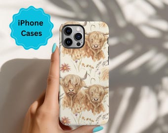 May include: A white iPhone case with a pattern of brown Highland cows and wildflowers. The case has a camera cutout and a white background.