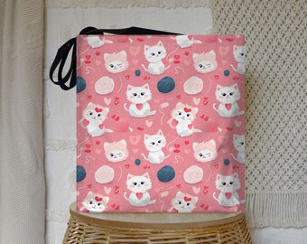 May include: Pink tote bag with a black handle and a repeating pattern of white kittens with pink hearts and yarn balls.