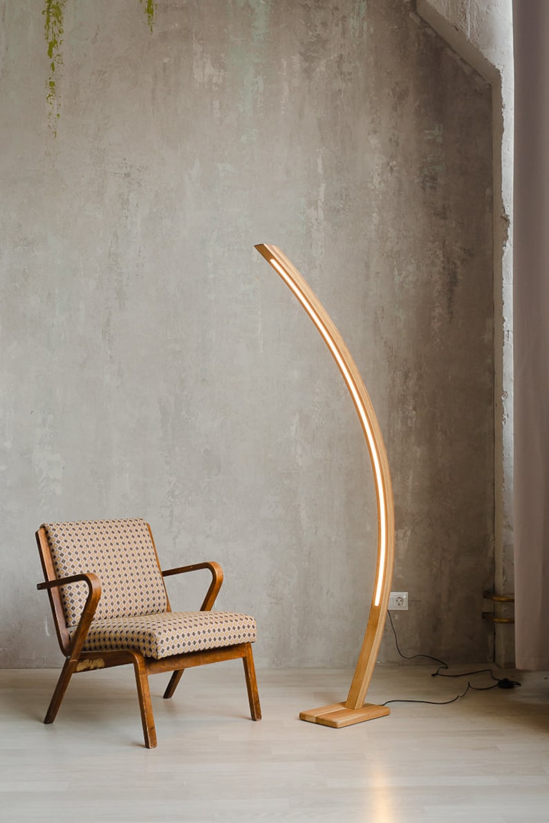 Curved wooden floor lamp with remote control, to adjust the brightness, you can also choose the temperature of the glow warm or neutral. The handmade LED floor lamp is made of solid oak, the tree can be tinted in 10 colors to choose from