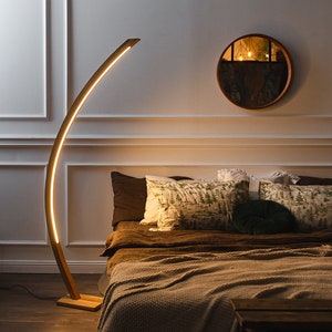 A bright wooden floor lamp will fit perfectly into any space, be it a bedroom or living room. The floor lamp includes a remote control with adjustable brightness. The tall oak floor lamp is made by hand. The LED floor lamp has a wooden base.