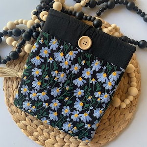 May include: A small black fabric bag with a floral pattern and a button closure. The bag is embroidered with blue and yellow flowers on a black background.