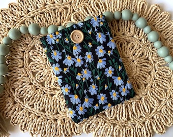 May include: A rectangular black fabric pouch featuring an embroidered pattern of light blue daisy-like flowers with yellow centers and green stems. The pouch is secured at the top center with a single, round, light brown wooden button.
