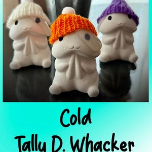 May include: Three white ceramic figures with knitted hats in white, orange, and purple. Each figure has a smiling face and a small, round pom-pom on top of the hat. The text "Cold Tally D. Whacker" is at the bottom.
