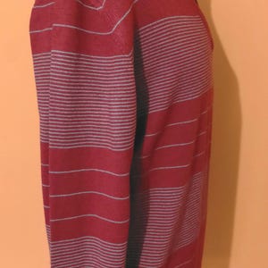 May include: A long-sleeved sweater with red and white stripes.