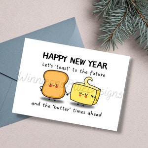 May include: A greeting card with a cartoon illustration of a slice of toast and a stick of butter holding hands. The text reads "Happy New Year. Let's 'toast' to the future and the 'butter' times ahead."