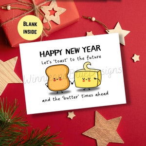 May include: A white card with a happy new year greeting featuring a cartoon toast and butter with the text "Let's 'toast' to the future and the 'butter' times ahead."