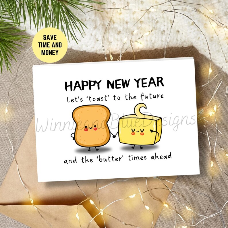 May include: A white card with a happy new year greeting. The card features a cartoon illustration of a slice of toast and a stick of butter holding hands. The text reads "Happy New Year. Let's 'toast' to the future and the 'butter' times ahead."