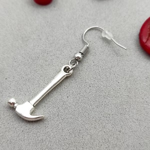 May include: Silver hammer shaped dangle earring with a silver hook.