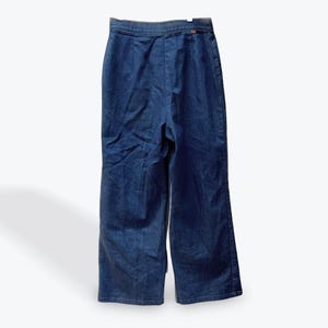 May include: A pair of dark blue denim wide-leg pants with a high waist and a button closure.
