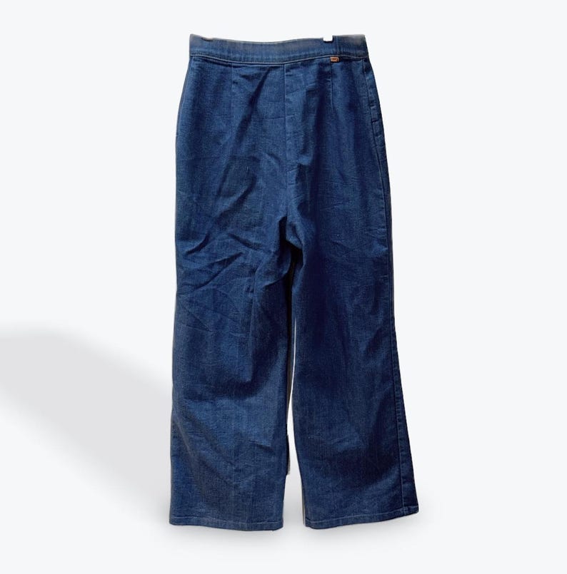 May include: A pair of dark blue denim wide-leg pants with a high waist and a button closure.