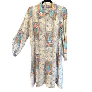 May include: A long-sleeved button-down shirt featuring a repeating pattern of rectangular panels. Each panel contains a colorful illustration of a figure set against a background of intricate, swirling black and white line art.