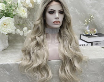 May include: A long, wavy, light blonde wig with a dark blonde root. The wig is styled in loose waves and falls to the shoulders.