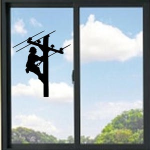 May include: A black silhouette of a utility worker climbing a utility pole, set against a backdrop of a blue sky with fluffy white clouds. The image is framed by a dark window.