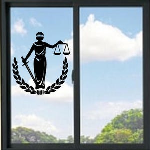 Könnte beinhalten: Schwarze Silhouette der Justitia mit Schwert und Waage, umrahmt von einem Lorbeerkranz. Die blind dargestellte Figur steht im Zentrum eines Fensters, vor dem Hintergrund eines blauen Himmels mit Wolken und grüner Vegetation.