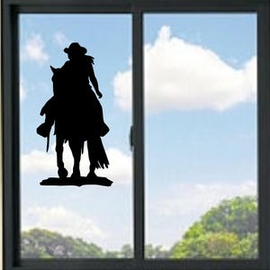 May include: Black silhouette of a person riding a horse, wearing a cowboy hat and a long coat. The image is set against a backdrop of a blue sky with clouds and a window frame.