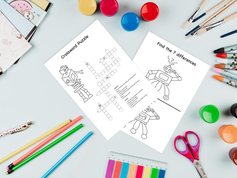 Puede incluir: Una hoja de trabajo imprimible en blanco y negro con dos ilustraciones de robots. Un robot est&aacute; en un crucigrama y el otro en un juego de 'Encuentra las 7 diferencias'. La hoja de trabajo est&aacute; rodeada de pintura de colores, pinceles, l&aacute;pices y tijeras.