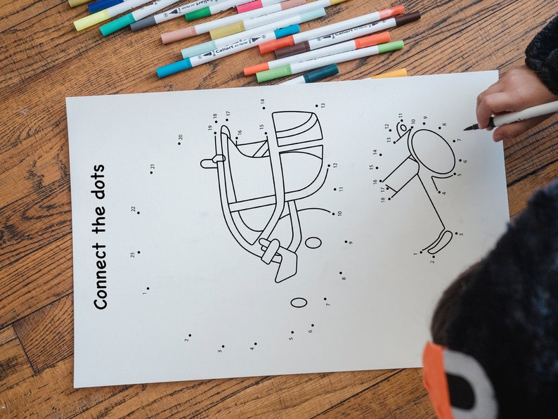 May include: A black and white connect-the-dots activity sheet with two images: a football helmet and a football. The sheet has the text "Connect the dots" printed on the left side.
