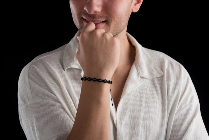 Black adjustable bracelet made of durable parachute cord, featuring matte hematite beads and a sterling silver slider for a custom fit.