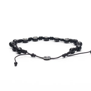 Black adjustable bracelet made of durable parachute cord, featuring matte hematite beads and a sterling silver slider for a custom fit.
