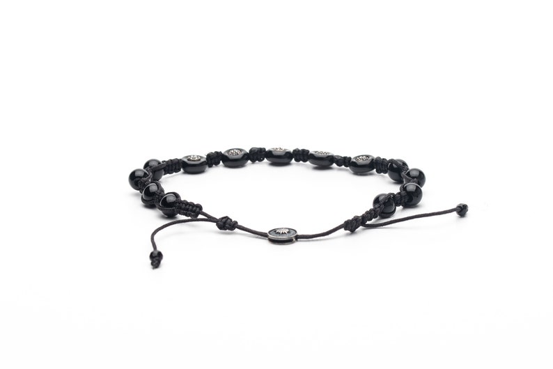 Black adjustable bracelet made of durable parachute cord, featuring matte hematite beads and a sterling silver slider for a custom fit.