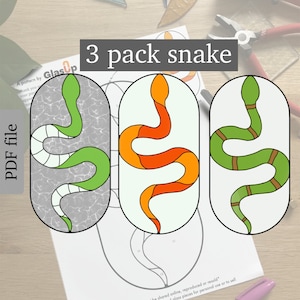 Op de afbeelding: Een printbaar PDF-patroon voor drie glas-in-lood-slangontwerpen. De slangen zijn in de kleuren groen, oranje en bruin. Het patroon heeft de titel "3 pack snake".