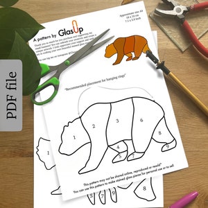 Op de afbeelding: Een printbaar patroon voor een glas-in-loodbeer. Het patroon is genummerd van 1 tot en met 9 en bevat instructies voor het assembleren van de glas-in-loodstukken. Het patroon is ongeveer 18 cm bij 10 cm.