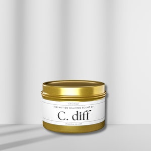 May include: Gold metal candle tin with a white label that reads "The not so calming scent of C. diff all-natural soy wax candle".