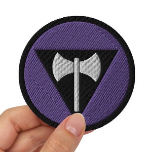 May include: Purple and black embroidered patch with a white axe symbol inside a triangle.