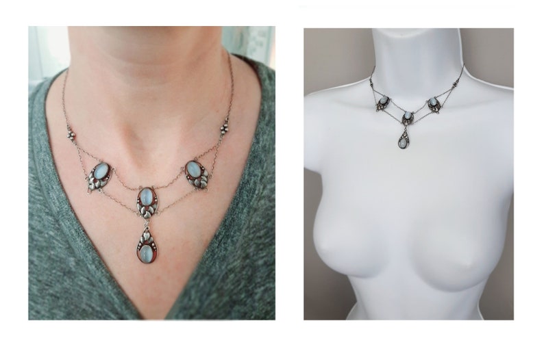 Puede incluir: Un collar de plata con un colgante en forma de l&aacute;grima y piedras ovaladas. El collar tiene dos cadenas y est&aacute; adornado con peque&ntilde;as cuentas.
