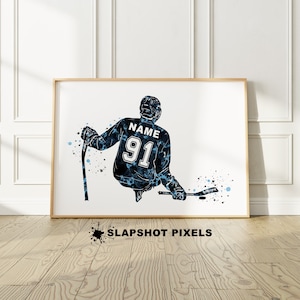 May include: A watercolor-style illustration of a hockey player in a blue and black jersey with the number 91 and the word "NAME" on the back. The player is holding a hockey stick and is in a skating position. The background is white with blue and black watercolor splatters.