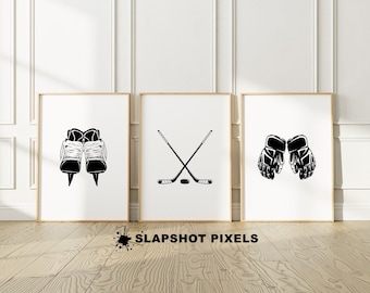 May include: Three black and white hockey-themed illustrations in frames. The first illustration shows a pair of hockey skates. The second illustration shows two hockey sticks crossed with a puck. The third illustration shows a pair of hockey gloves.