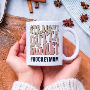 Hockey Mom 11oz Ceramic mug with graphic that says straight outta money, at the bottom it says hockey mom. This makes perfect hockey mom gifts for mothers day and a birthday, or to show your appreciation for your hockey mom, hockey coach or manager