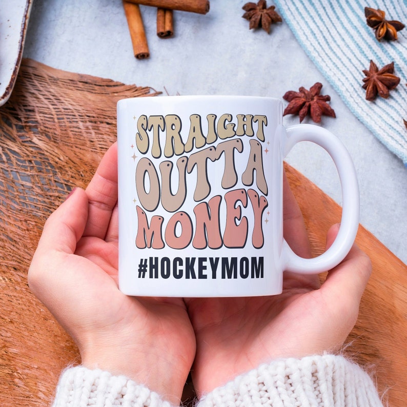 Hockey Mom 11oz Ceramic mug with graphic that says straight outta money, at the bottom it says hockey mom. This makes perfect hockey mom gifts for mothers day and a birthday, or to show your appreciation for your hockey mom, hockey coach or manager