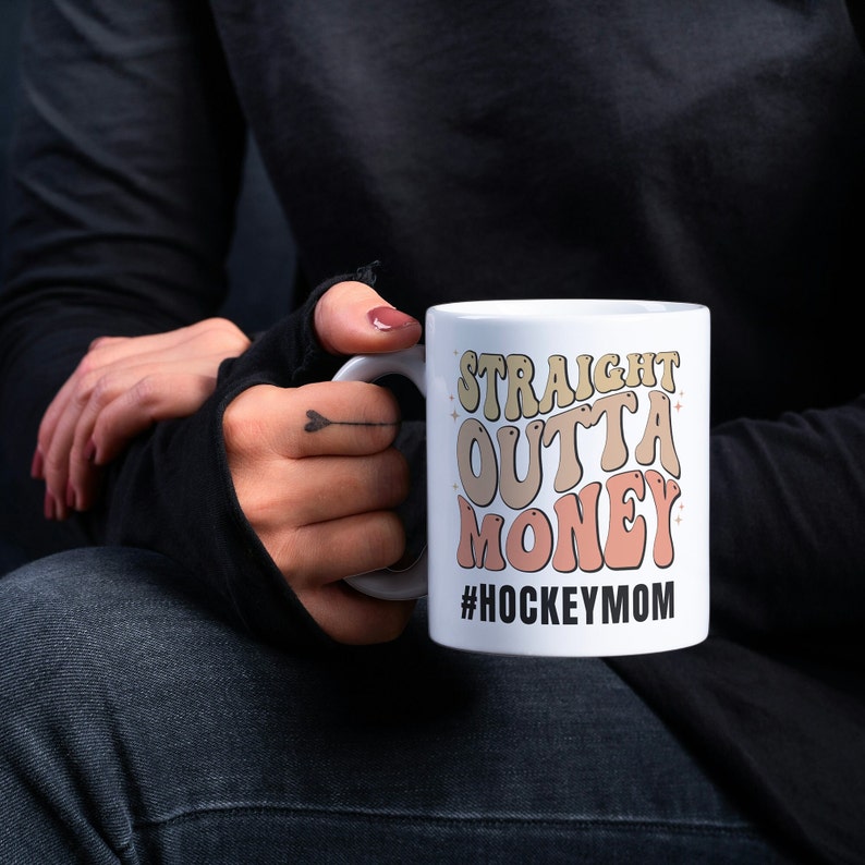 Hockey Mom 11oz Ceramic mug with graphic that says straight outta money, at the bottom it says hockey mom. This makes perfect hockey mom gifts for mothers day and a birthday, or to show your appreciation for your hockey mom, hockey coach or manager