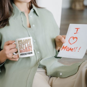 Hockey Mom 11oz Ceramic mug with graphic that says straight outta money, at the bottom it says hockey mom. This makes perfect hockey mom gifts for mothers day and a birthday, or to show your appreciation for your hockey mom, hockey coach or manager