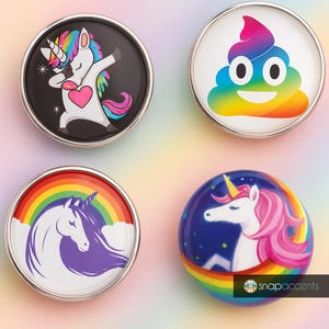 Może przedstawiać: Cztery okrągłe guziki ze srebrnymi obwódkami i kolorowymi wzorami. Jeden przedstawia jednorożca robiącego dabbing, drugi emoji tęczowej kupy, a dwa pozostałe jednorożce z tęczami. Guziki są prawdopodobnie do akcesoriów.