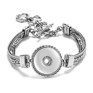 May include: Silver bracelet with a round snap charm. The bracelet has a braided chain design and a toggle clasp.