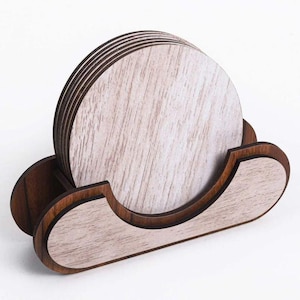 May include: A set of six round wooden coasters with a light wood grain pattern, displayed in a dark wood holder. The holder has a curved design with a slot to hold the coasters upright. The coasters and holder are made of wood.