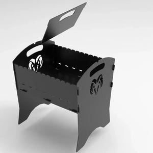 May include: A black metal portable grill with a handle on the lid and sides. The grill features cut-out ram head designs on the sides. The lid is open, revealing the interior of the grill.