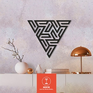 May include: Black geometric wall art in a triangular shape, featuring an intricate, interwoven design. The artwork is mounted on a textured wall above a white cabinet. A gold-colored lamp and decorative vases are also visible. The image includes the text "HASVECTOR Laser Cut, Wooden Models..."