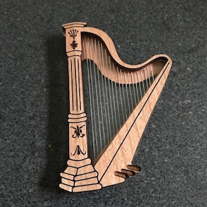May include: A wooden harp with intricate carvings and a clear string section. The harp is a decorative piece with a traditional design.